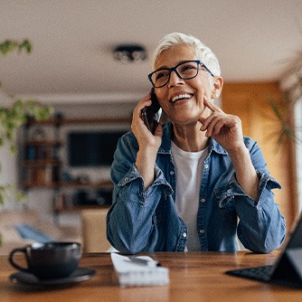 Woman smiling while talking on phone at home