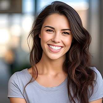 Closeup of woman in grey shirt smiling outside